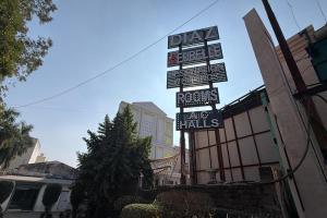 a sign for a hotel with street signs on it at Hotel Beubelle in Meerut
