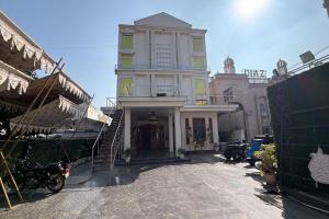 a large white building with a staircase in front of it at Hotel Beubelle in Meerut +22 photos