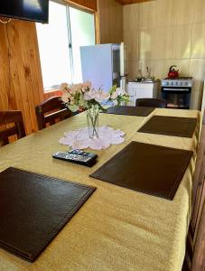 eine Küche mit einem Tisch, auf dem eine Blumenvase steht in der Unterkunft Cabañas Anny 1 in Linares + 7 Fotos