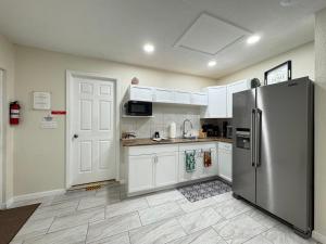 a kitchen with white cabinets and a stainless steel refrigerator at Sunshine Nest in Lehigh Acres