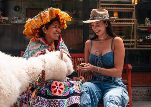 two women are sitting on a bench with a dog at Union Hotel Cusco in Cusco