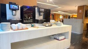 a restaurant with a counter with plates on it at Tai Pan Hotel in Bangkok