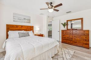 a white bedroom with a bed and a ceiling fan at 601 Benedictine Ter in Sebastian