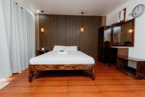 a bedroom with a bed and a clock on the wall at Villa Gertrudes Beach Resort in Surigao +58 photos