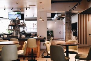 a restaurant with tables and chairs and a bar at Hotel Indigo Saint Louis Central West End by IHG in Saint Louis