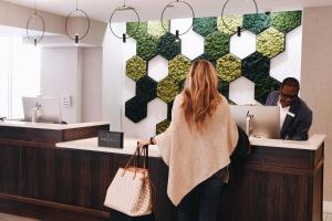 a woman standing in front of a cash register at Hotel Indigo Saint Louis Central West End by IHG in Saint Louis