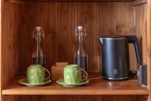 a coffee maker and two glass bottles on a shelf at Kirani House - Joglo Villa Bali in Darmasaba