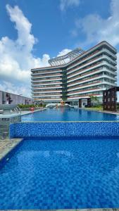 a large hotel with a swimming pool in front of a building at Nuvasa Bay Studio Apartment 6A10 in Nongsa
