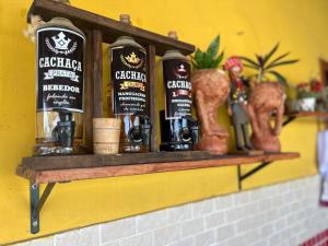 a shelf with bottles of alcohol on a wall at Rancho tareco e mariola in Petrolina