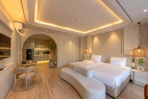 a bedroom with a large white bed and a couch at Emerald Boutique Hotel Phú Quốc in Phú Quốc