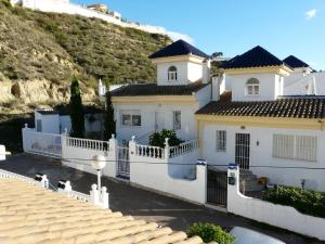 a white house with a balcony and a hill at Quesada Golf House in Ciudad Quesada