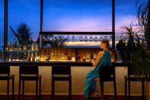 a woman in a blue dress sitting at a bar at Southern Beach Hotel & Resort Okinawa in Itoman