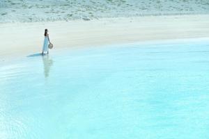 a woman in a white dress standing on a beach at Southern Beach Hotel & Resort Okinawa in Itoman