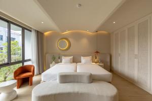 a bedroom with a large bed with a large window at Emerald Boutique Hotel Phú Quốc in Phú Quốc