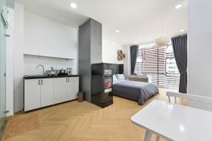 a bedroom with a bed and a kitchen and a table at M Home Riverside in Ho Chi Minh City