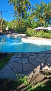 a picture of a swimming pool next to a resort at Les Chambres Des Vacoas in Saint-Philippe