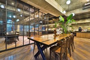 a dining room with a large wooden table and chairs at 브라운도트호텔동탄역점 구 js더클래식호텔 in Hwaseong