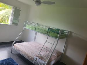 a bunk bed in a room with a window at Villa familiale pensé pour vous in Les Abymes