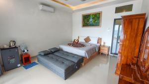 a bedroom with a bed and a couch in it at Dewata Beach House in Amed