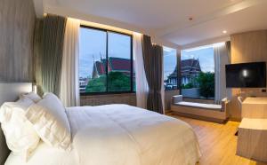 a bedroom with a large white bed and a large window at The Chedee Krungthep in Bangkok +170 photos