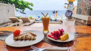 a table with two plates of food and a drink at Dewata Beach House in Amed +27 photos