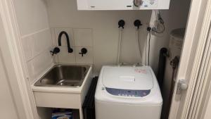 a small kitchen with a sink and a washing machine at Higgi Drive 6 in Mount Hotham +5 photos