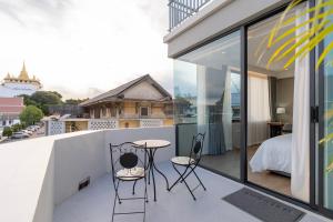 a balcony with a table and chairs on it at The Chedee Krungthep in Bangkok