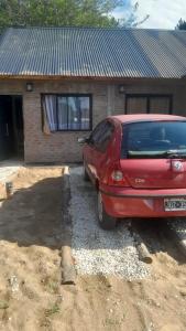 a red car parked in front of a house at Los Almendros in Nueva Atlantis