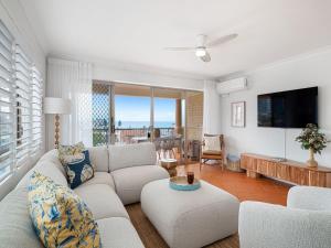 a living room with a couch and a tv at Seabreeze unit 5, Kings Beach in Caloundra