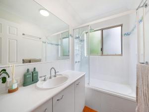 a white bathroom with a sink and a shower at Seabreeze unit 5, Kings Beach in Caloundra +7 photos