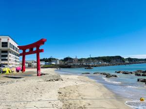 a red object on the beach next to the water at Villa 勝浦 in Katsuura