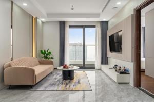 a living room with a couch and a tv at Aravelle Suites managed by 22Land in Hanoi