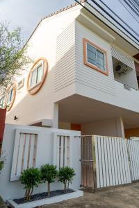 a white house with trees in front of it at Reach Home Hatyai in Hat Yai