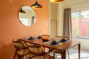 a dining room table with chairs and a mirror at Reach Home Hatyai in Hat Yai