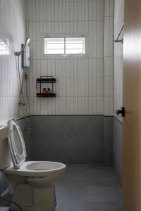 a bathroom with a toilet and a sink and a window at Reach Home Hatyai in Hat Yai +8 photos