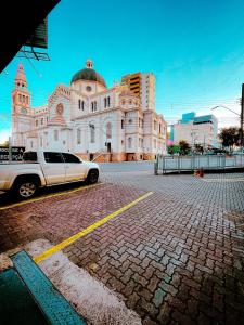 a white truck parked in front of a building at Hotel Perez in Pouso Alegre