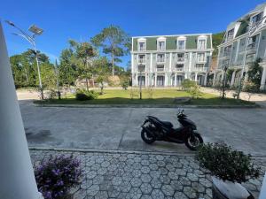 a motorcycle parked in front of a large building at Camly Chic Villa in Da Lat