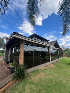 a house with large glass windows in a yard at Pousada Bonetti Quarto 4 in Santa Rosa