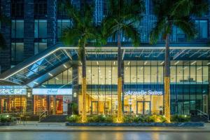 a large building with palm trees in front of it at Aravelle Suites managed by 22Land in Hanoi