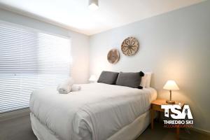 a bedroom with a large bed with a clock on the wall at Snowman 8 Penthouse in Thredbo