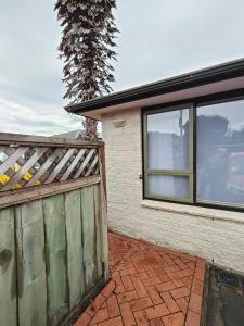 a house with a wooden gate and a fence at Orchards Retreat in Paraparaumu Beach