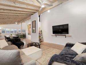 a living room with two couches and a flat screen tv at Sea Side Glide at Maloneys Hide in Maloney's Beach
