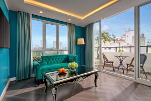 a living room with a green couch and a large window at Minerva Church Hotel in Hanoi