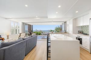 a kitchen and living room with a view of the ocean at Waves #9 by Discover Stradbroke in Point Lookout