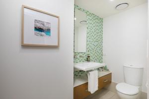 a bathroom with a white toilet and a sink at Waves #9 by Discover Stradbroke in Point Lookout +8 photos