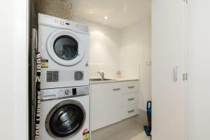 a laundry room with a washer and dryer at Waves #9 by Discover Stradbroke in Point Lookout
