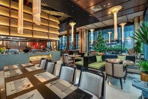 a restaurant with tables and chairs and a christmas tree at Aravelle Suites managed by 22Land in Hanoi