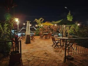 a patio with tables and chairs at night at Posada Campestre La Casona in Villa de Leyva