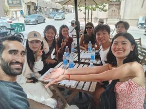 a group of people sitting at a picnic table at Heritage Hostel Muscat in Muscat