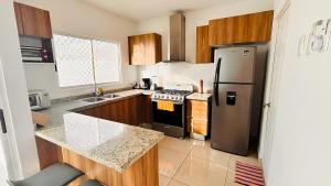 a kitchen with a stove and a refrigerator at Casa amplia y privada con alberca para una escapada perfecta in Playa del Carmen